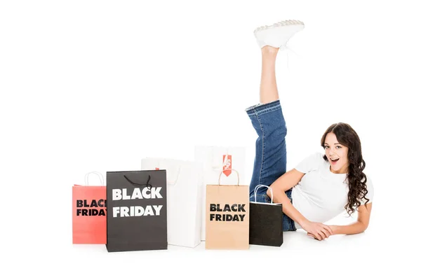Menina animado posando em sacos de compras com sinais de venda sexta-feira preto isolado no branco — Fotografia de Stock