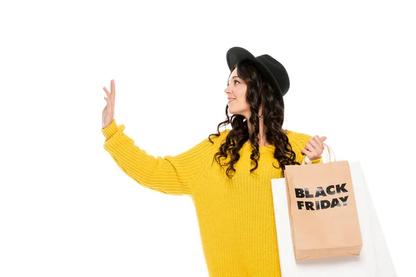 Beautiful stylish shopaholic gesturing and holding shopping bags with black friday symbols, isolated on white — Stock Photo