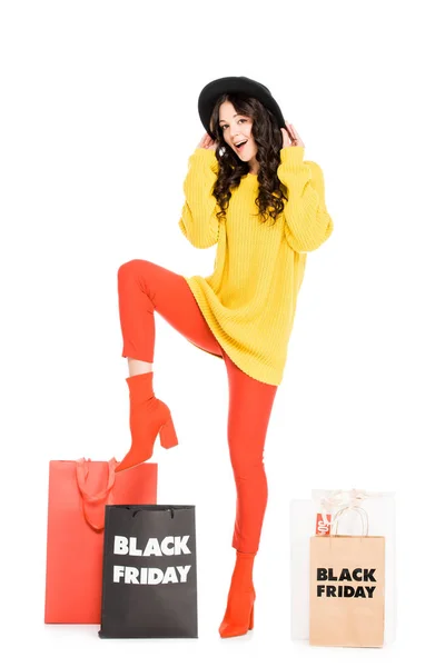 Excited stylish girl posing near shopping bags on black friday sale, isolated on white — Stock Photo