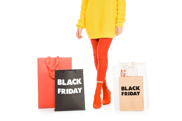 Abgeschnittene Ansicht von stilvollen Mädchen posiert in der Nähe von Einkaufstaschen am Black Friday Sale, isoliert auf weiß — Stockfoto