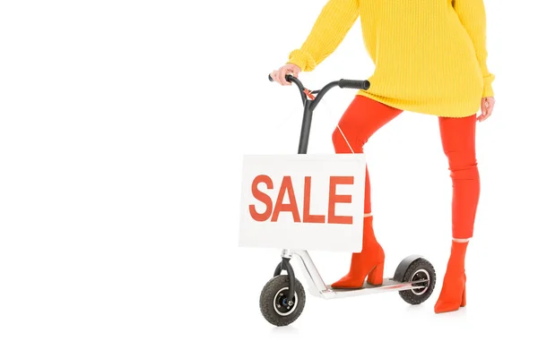 Обрезанный вид стильной девушки на скутере с табличкой продажи изолированы на белом — стоковое фото