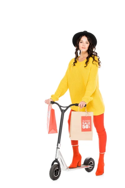 Attractive customer riding scooter with shopping bags isolated on white — Stock Photo