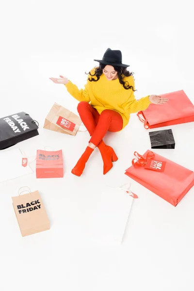 Шопоголік сидить у сумках на продаж у чорну п'ятницю, ізольований на білому — стокове фото