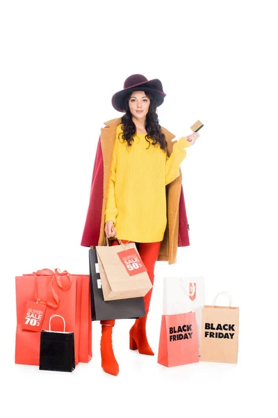 Приваблива дівчина тримає кредитну картку і сумки для чорної п'ятниці ізольовані на білому — стокове фото