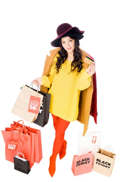 Menina bonita segurando cartão de crédito e sacos de compras para sexta-feira preta isolada no branco — Fotografia de Stock