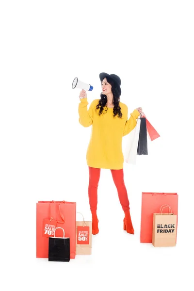 Shopaholic à la mode avec des sacs à provisions criant dans le mégaphone pour la promotion du vendredi noir isolé sur blanc — Photo de stock