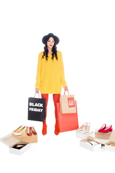 Stylish girl holding shopping bags with black friday symbol isolated on white with footwear — Stock Photo