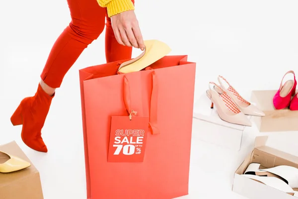 Vista recortada de mujer con bolsa de compras y etiqueta de venta aislada en blanco con cajas de calzado - foto de stock