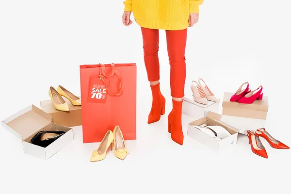 Vista recortada de chica con bolsa de compras roja y etiqueta de venta aislada en blanco con cajas de calzado — Stock Photo