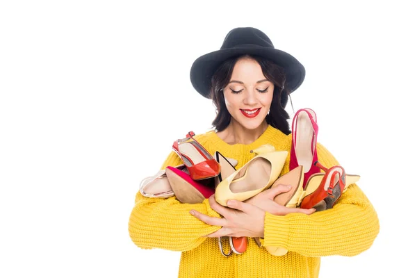 Bela menina sorridente segurando monte de sapatos da moda isolado no branco — Fotografia de Stock