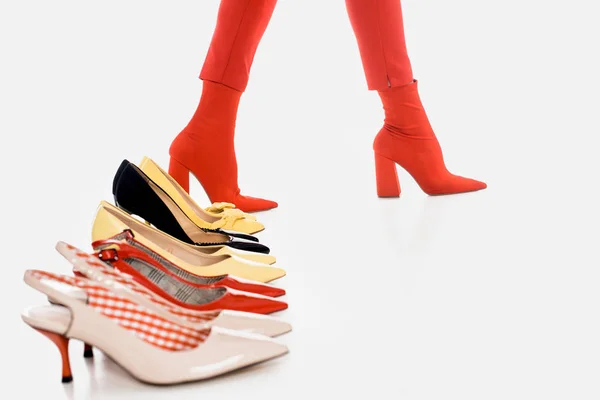 Обрезанный снимок женских ног и размещенные ботинки изолированы на белом — стоковое фото