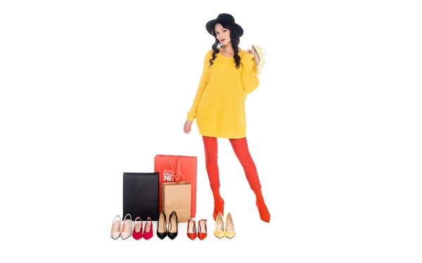 Mulher elegante de pé perto de sacos de compras com venda tag e sapatos femininos arranjados isolados no branco — Fotografia de Stock