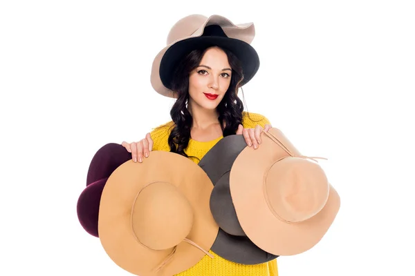 Retrato de mujer hermosa sosteniendo sombreros femeninos aislados en blanco - foto de stock