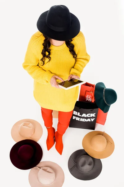 Mujer de moda con la tableta en las manos, sombreros y bolsas de compras en torno aislado en blanco - foto de stock