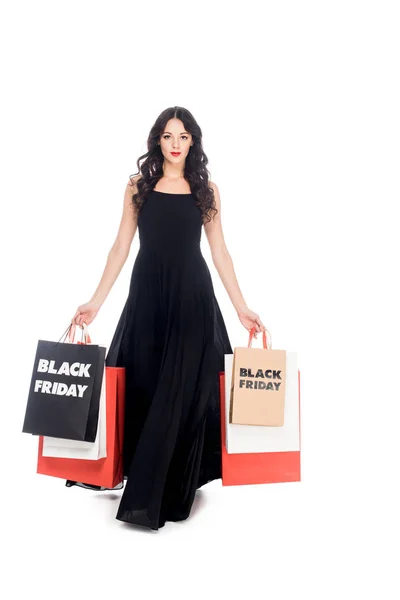 Bella donna elegante in abito nero con shopping bags isolato su bianco — Foto stock