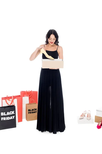 Приваблива жінка тримає взуттєву коробку ізольовано на білому, покупки та концепції чорної п'ятниці — стокове фото