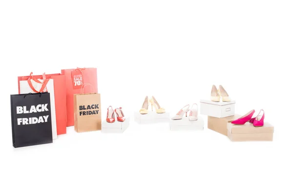 Vista ravvicinata di scarpe femminili e shopping bag con scritta nera venerdì isolato su bianco — Foto stock
