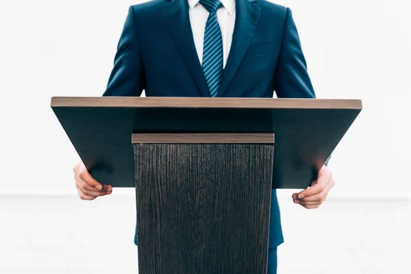 Cropped image of lecturer standing at podium tribune during seminar in conference hall — Stock Photo