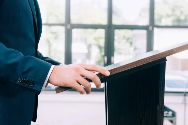 Imagen recortada del profesor de pie en el podio tribuna durante el seminario en la sala de conferencias - foto de stock