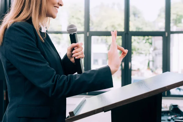 Imagen recortada del profesor mostrando gesto bien en el podio tribuna durante el seminario en la sala de conferencias - foto de stock