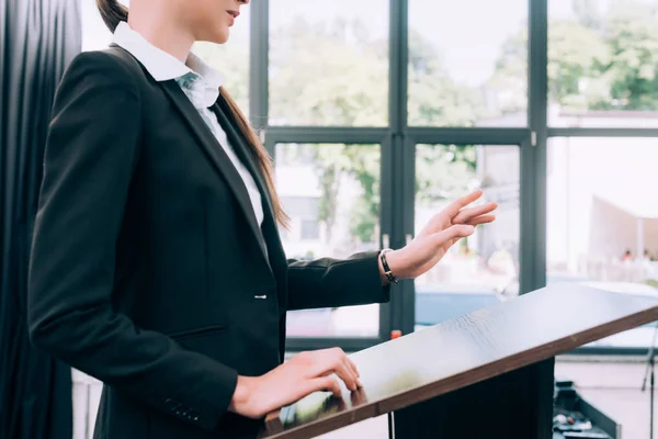 Imagen recortada del profesor de pie y el gesto en el podio tribuna durante el seminario en la sala de conferencias - foto de stock