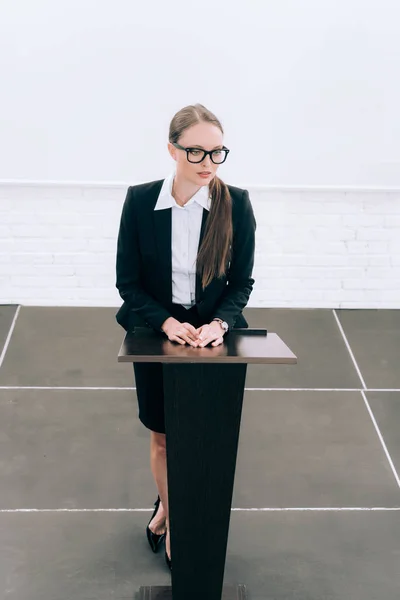 High angle view of attractive lecturer standing at podium tribune during seminar in conference hall — Stock Photo