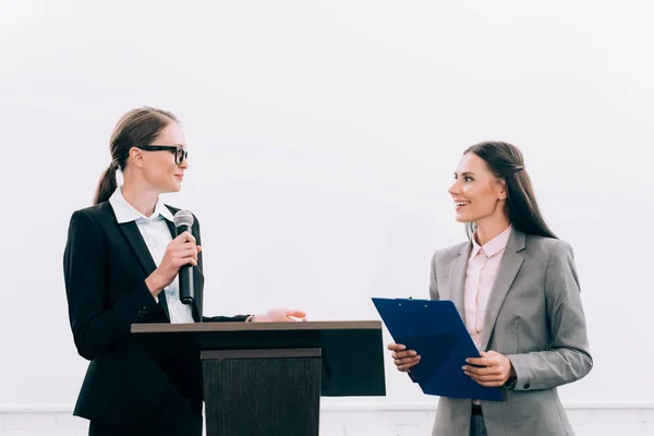 Attrayant conférencier regardant assistant pendant le séminaire dans la salle de conférence — Photo de stock