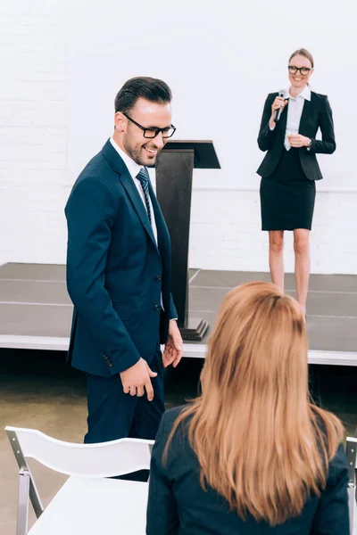 Lächelnde Teilnehmer sprechen während des Seminars im Konferenzsaal — Stockfoto