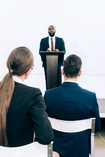 Beau conférencier afro-américain parlant pendant le séminaire dans la salle de conférence — Photo de stock