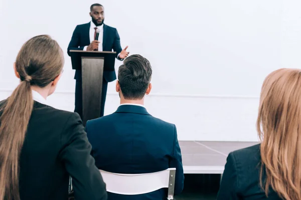 Beau conférencier afro-américain parlant devant la salle de conférence du public — Photo de stock