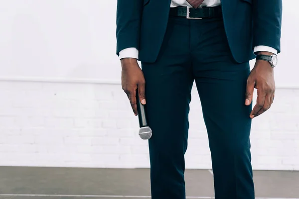 Cropped image of african american businessman holding microphone during seminar in conference hall — Stock Photo