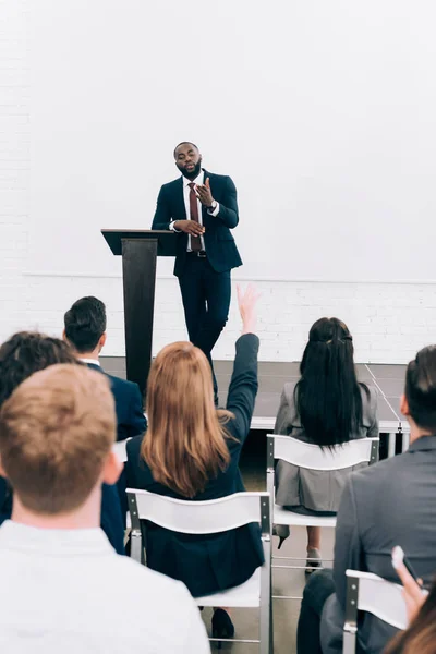 Conférencier afro-américain parlant au public et faisant des gestes pendant le séminaire dans la salle de conférence — Photo de stock