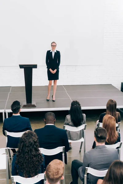 High angle view of attractive lecturer looking at multiethnic audience during seminar in conference hall — Stock Photo