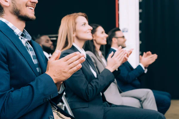 Uomini d'affari multiculturali sorridenti applaudono durante il seminario aziendale nella sala conferenze — Foto stock