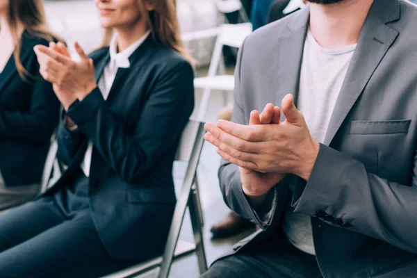 Visión parcial de los empresarios aplaudiendo durante el seminario de negocios en la sala de conferencias - foto de stock