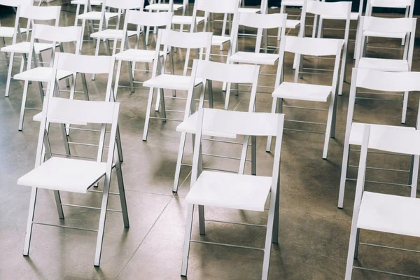 Nahaufnahme von arrangierten leeren weißen Stühlen im Konferenzsaal — Stockfoto