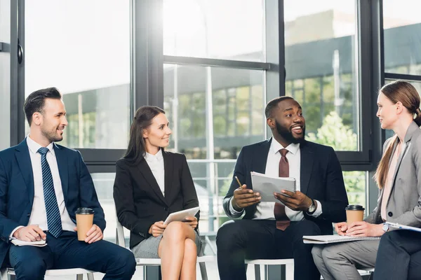 Smiling multicultural businesspeople having meeting in conference hall — Stock Photo