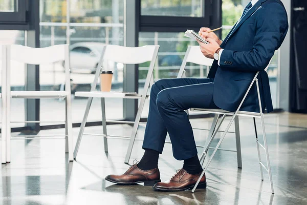 Vista parcial del hombre de negocios con cuaderno en la sala de conferencias - foto de stock