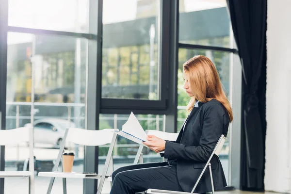 Vista lateral de empresária com bloco de notas à espera de palestra na sala de conferências — Stock Photo