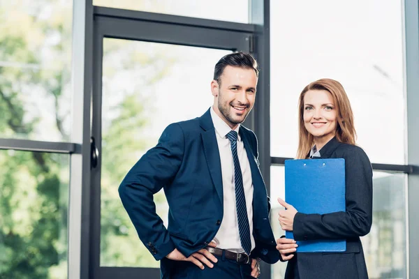 Smiling business colleagues before business lecture in conference hall — Stock Photo