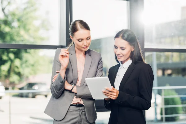 Porträt von Geschäftsfrauen, die gemeinsam Tablets im Konferenzsaal benutzen — Stockfoto