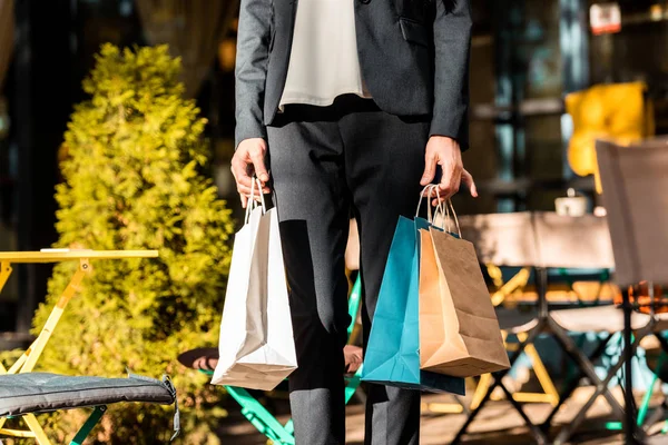 Imagem cortada de mulher andando com sacos de papel de compras na rua — Fotografia de Stock