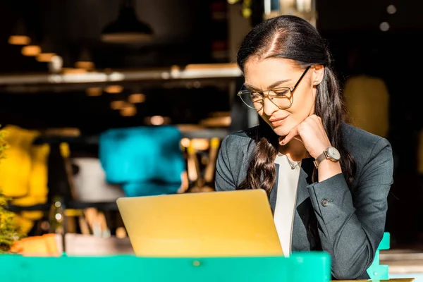 Beautiful freelancer working with laptop on restaurant terrace — Stock Photo