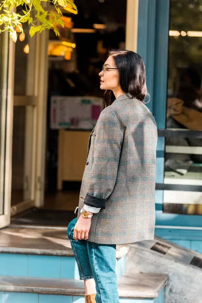 Belle femme élégante en veste près de l'entrée du restaurant — Photo de stock