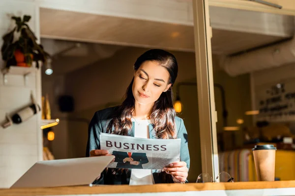 Attraktive Geschäftsfrau liest in Kaffeepause im Café Wirtschaftszeitung — Stockfoto