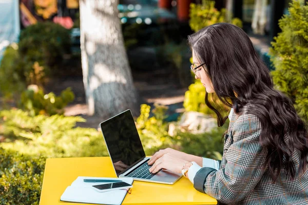 Brunette female freelancer working with laptop at restaurant terrace — Stock Photo