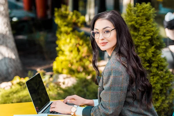 Attrayant brunette femme d'affaires télétravail avec ordinateur portable à la terrasse du restaurant — Photo de stock