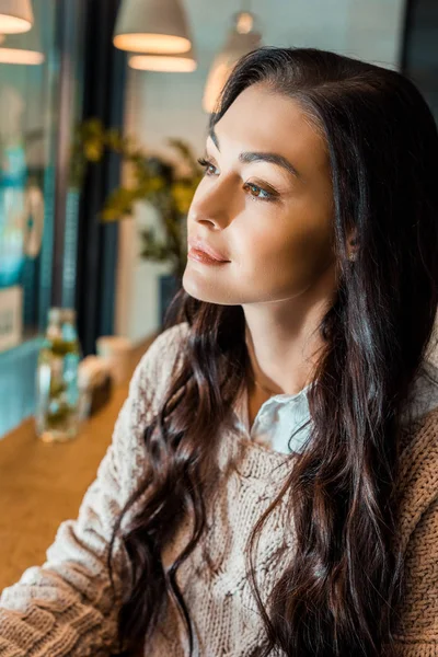 Beautiful brunette woman in autumn sweater in cafe — Stock Photo