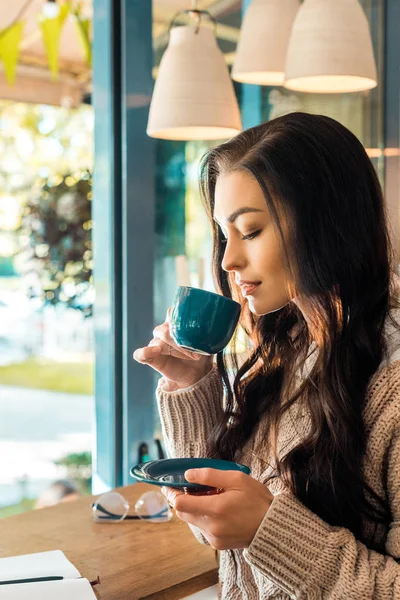 Atractiva mujer en suéter de otoño beber café en la cafetería - foto de stock