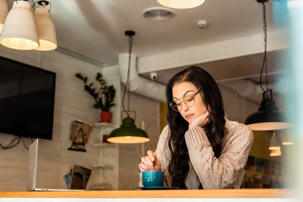 Belo freelancer chateado no café com laptop e xícara de café — Fotografia de Stock